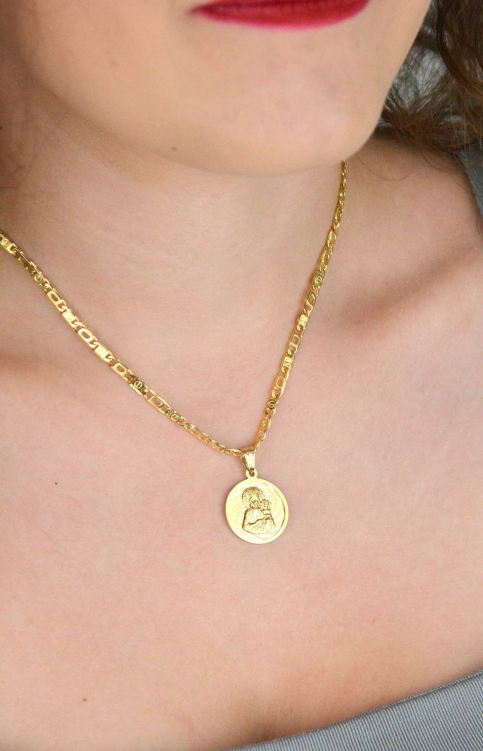 Złota zawieszka próby 585 z wizerunkiem Matki Boskiej z Dzieciątkiem. Wymiary 2 cm, waga 2,63 g. Klasyczny medalik religijny w eleganckiej formie.1.jpg